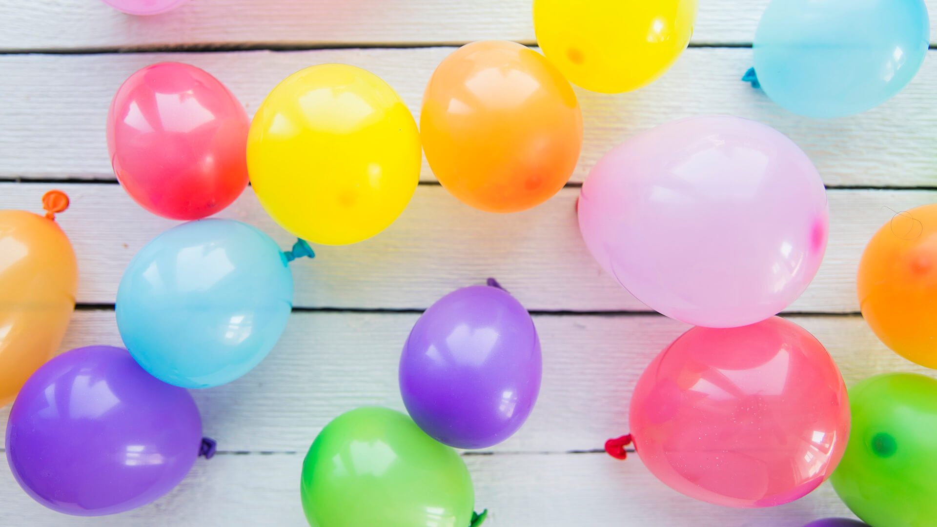 A number of colorful balloons attached to a wall