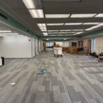 The 1st floor of Lane Road undergoing renovation with carpet flooring, ceiling fixtures, and construction materials.