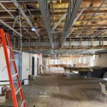 The branch's 1st floor space under renovation showing exposed ceiling with metal framing, insulation, and empty floor area.